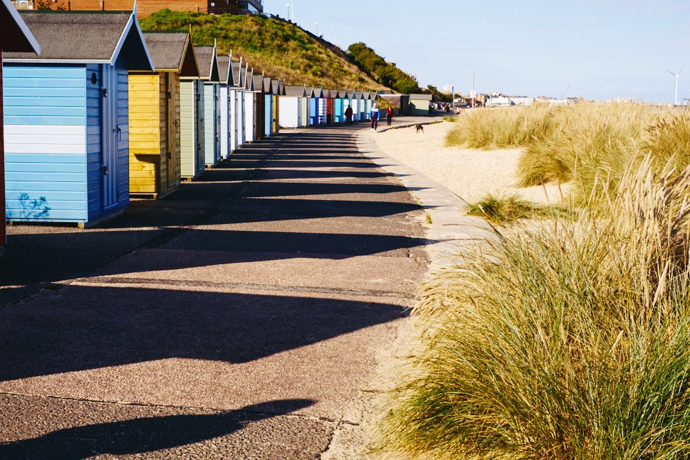 row of beach huts in afternoon sun