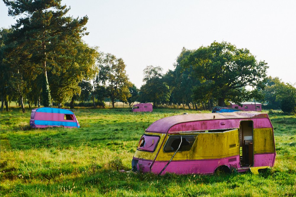 colourful abandoned caravans in a field