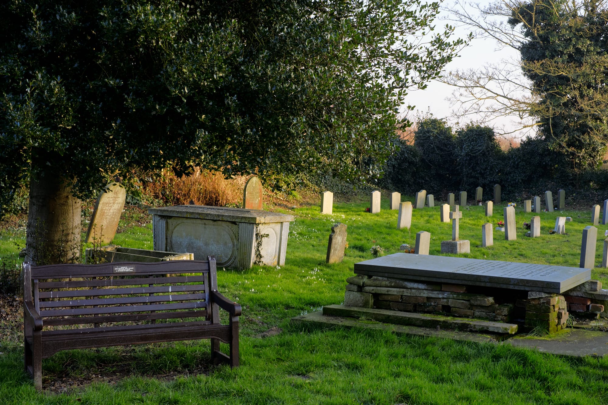 bench and gravestones in church grounds