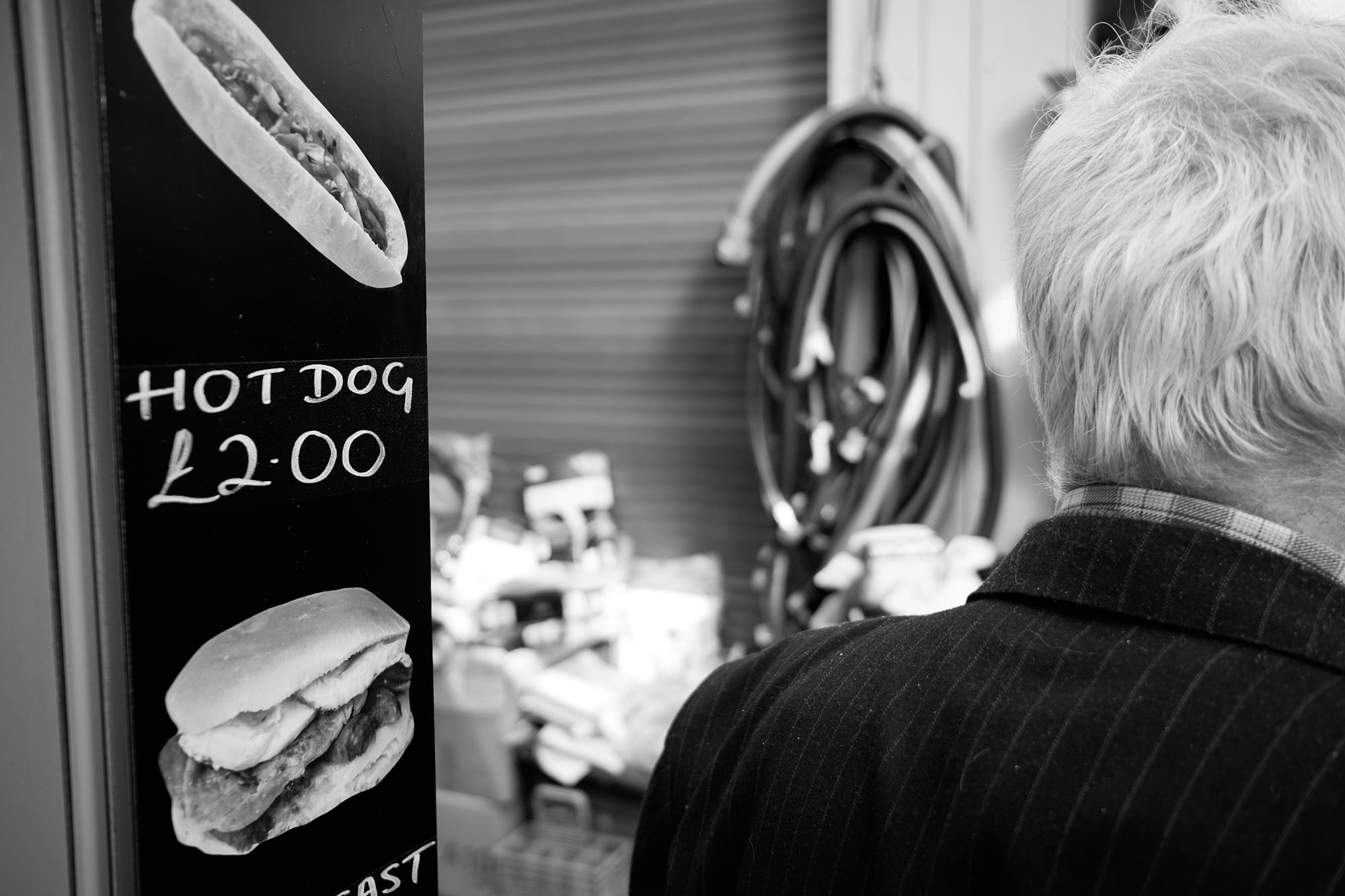 ‘Hot Dog’ sign and back of old man’s head