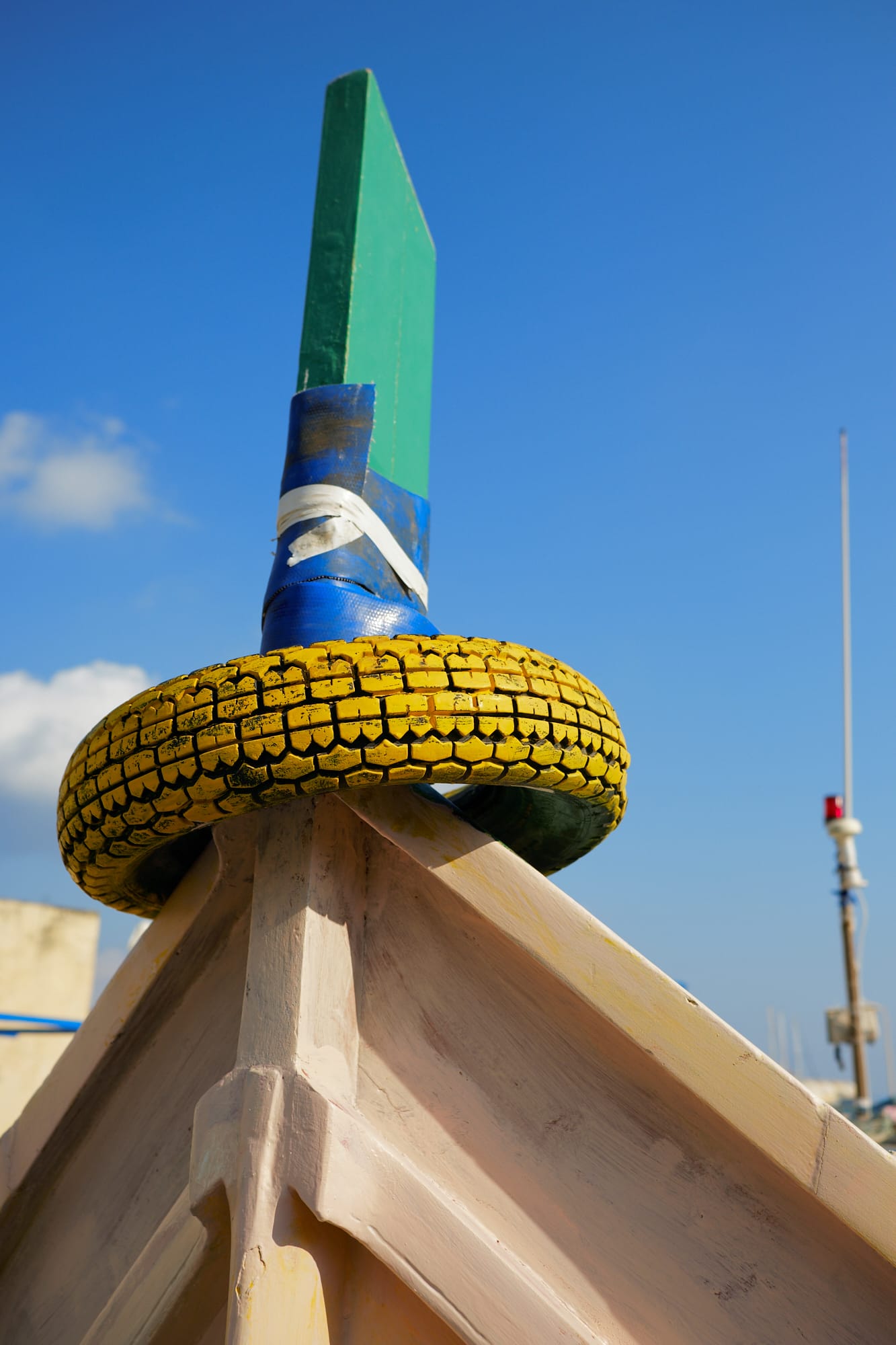 yellow painted tyre on boat prow