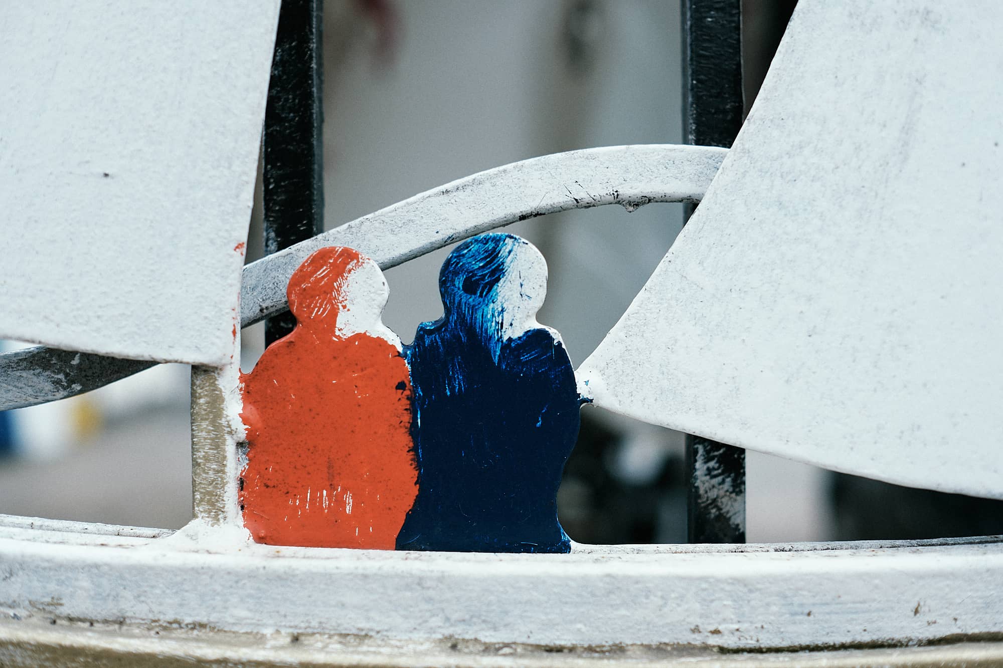 small painted human figures on a fence