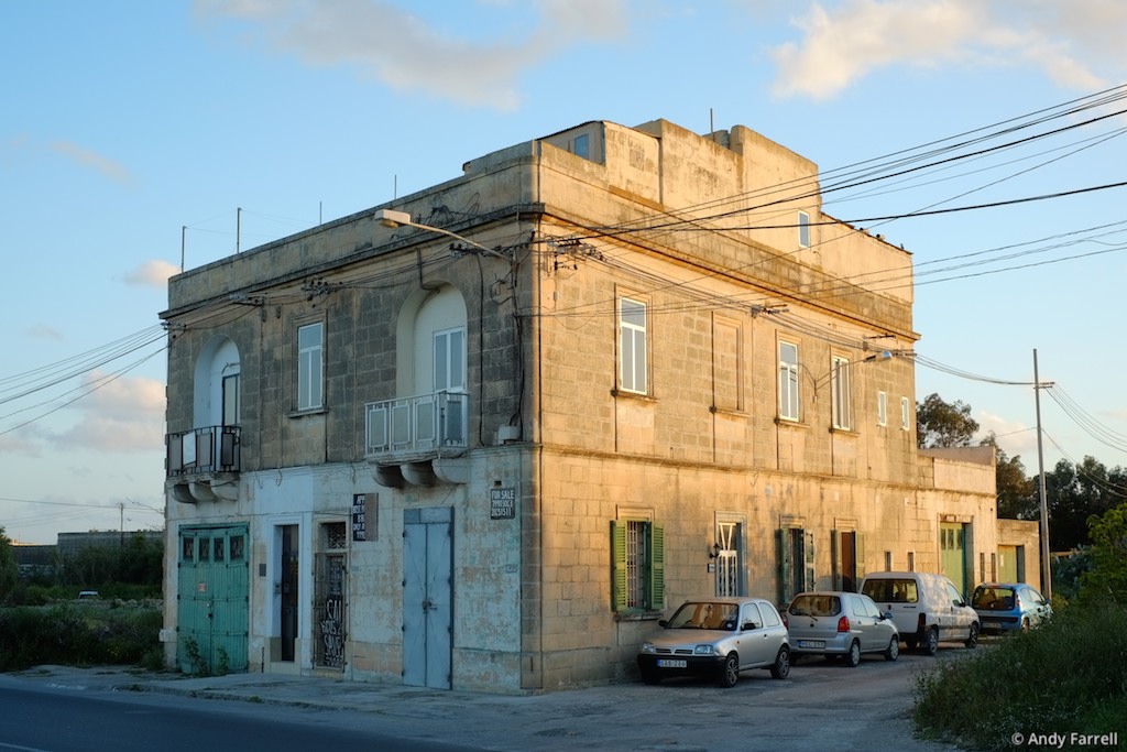 old house for sale, lit by the setting sun