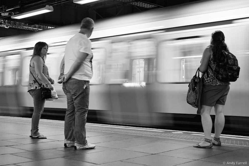 people in front of a motion-blurred tube train