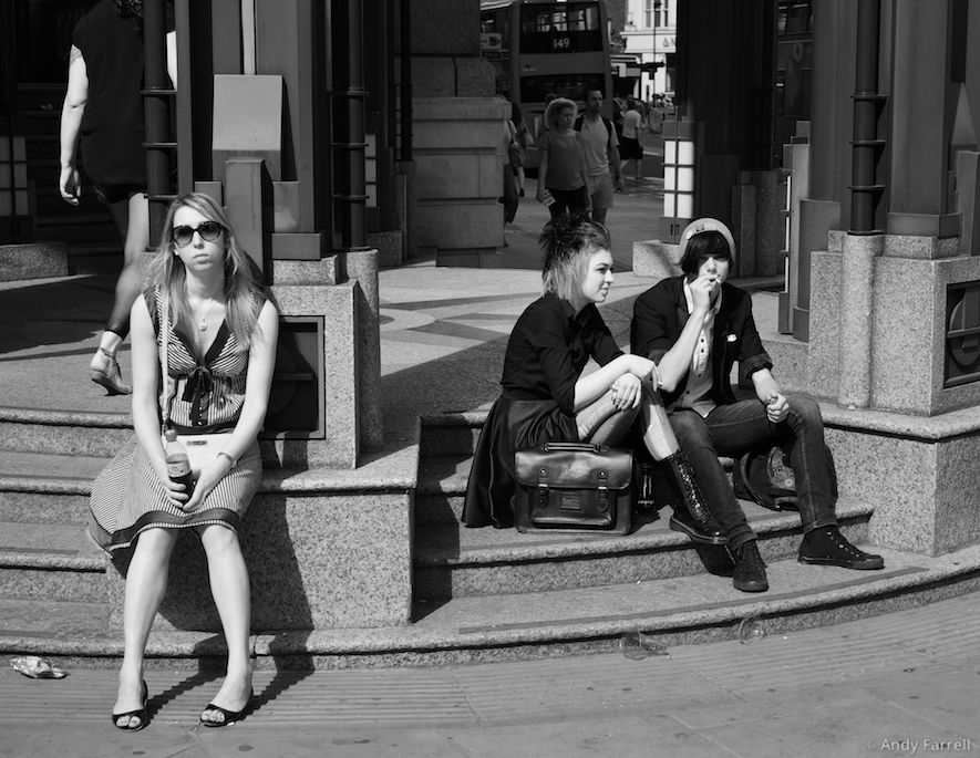 three people sitting on round steps