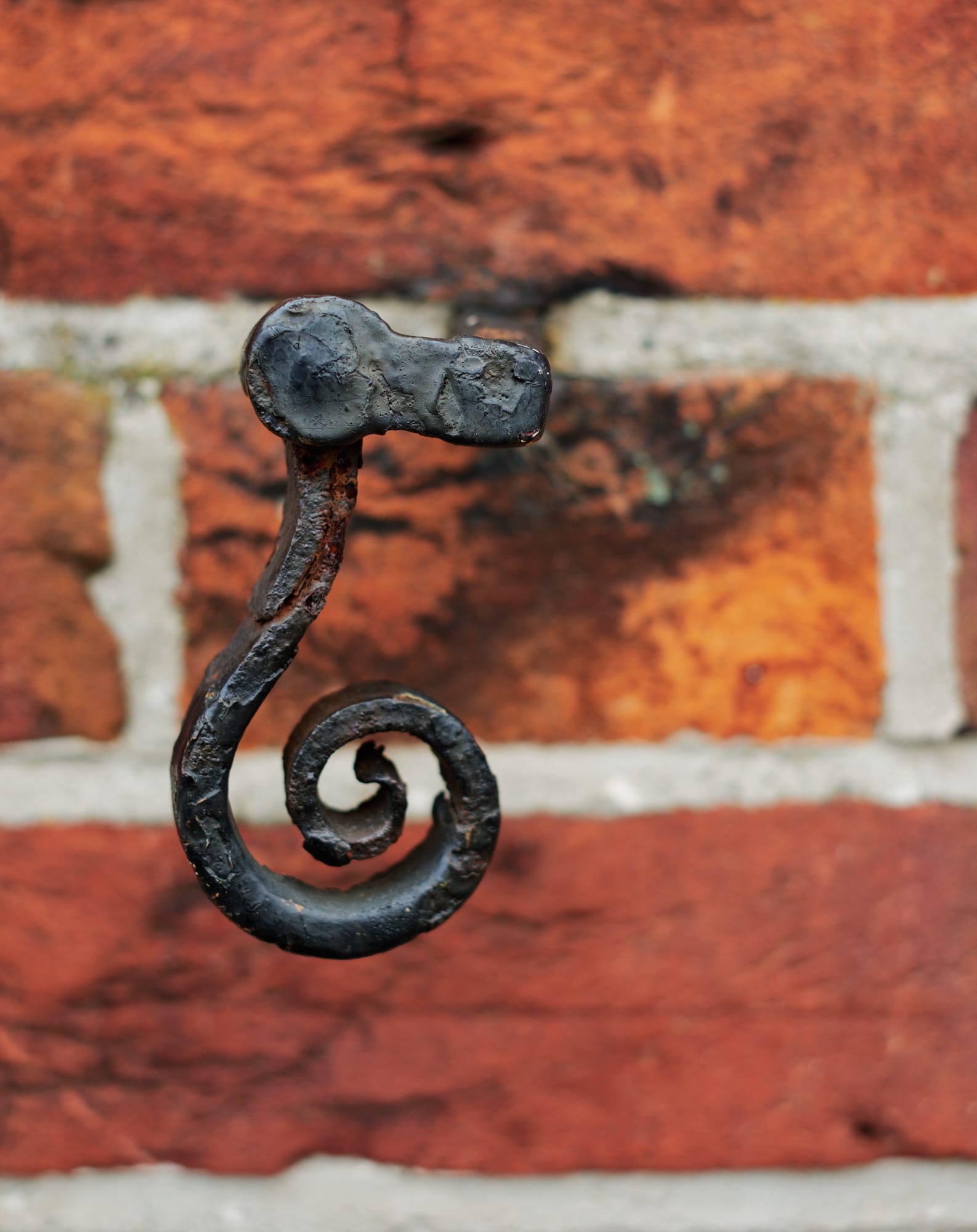 iron hook protruding from brick wall