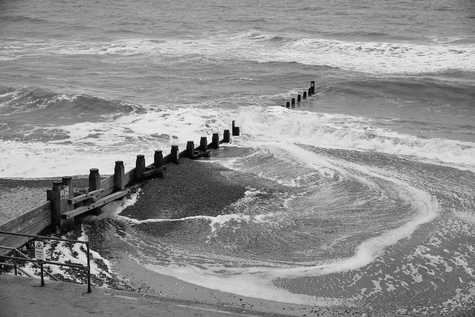 foamy sea swirling swirling around a groyne