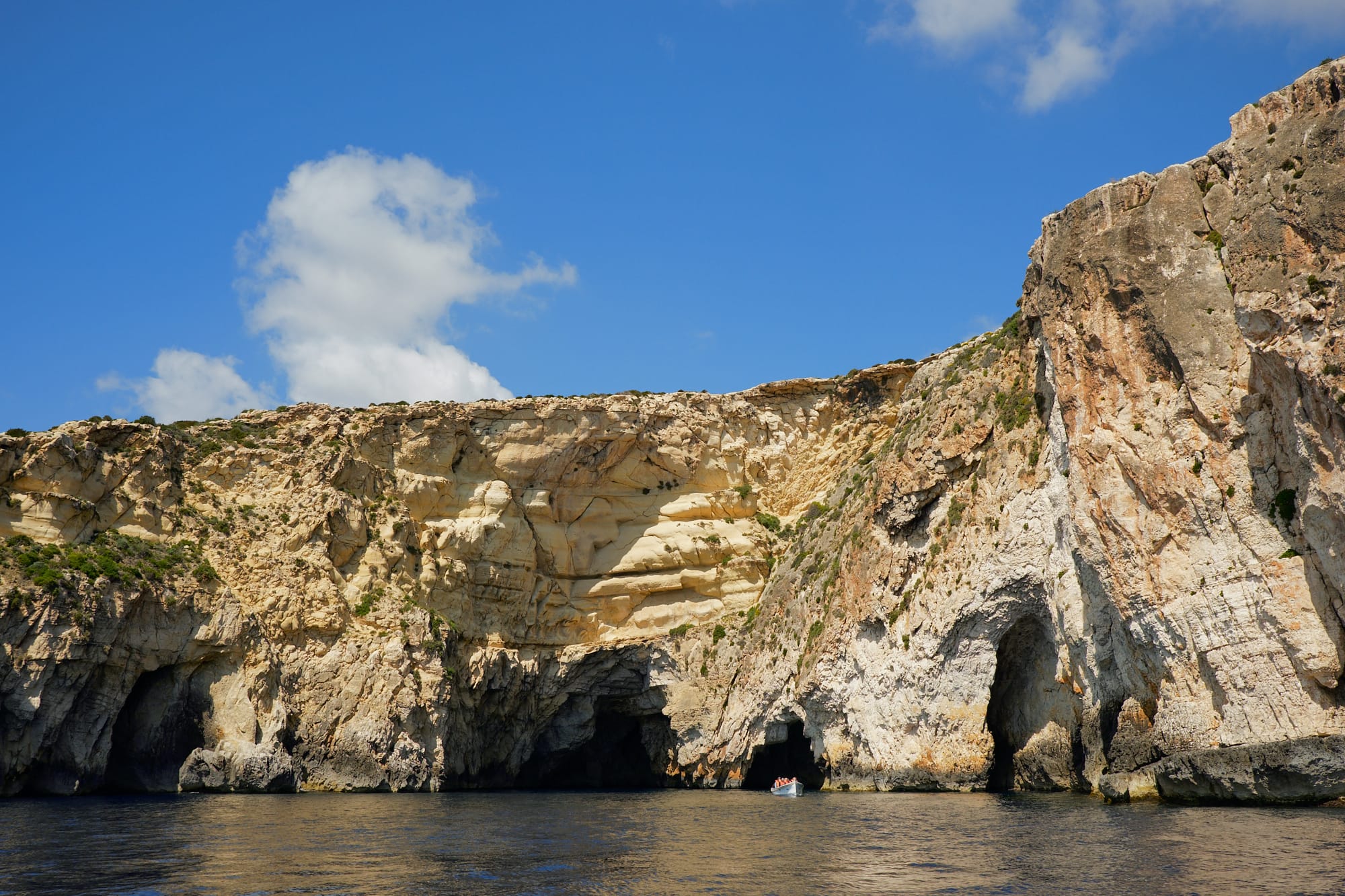 boat in the distance exiting a cave