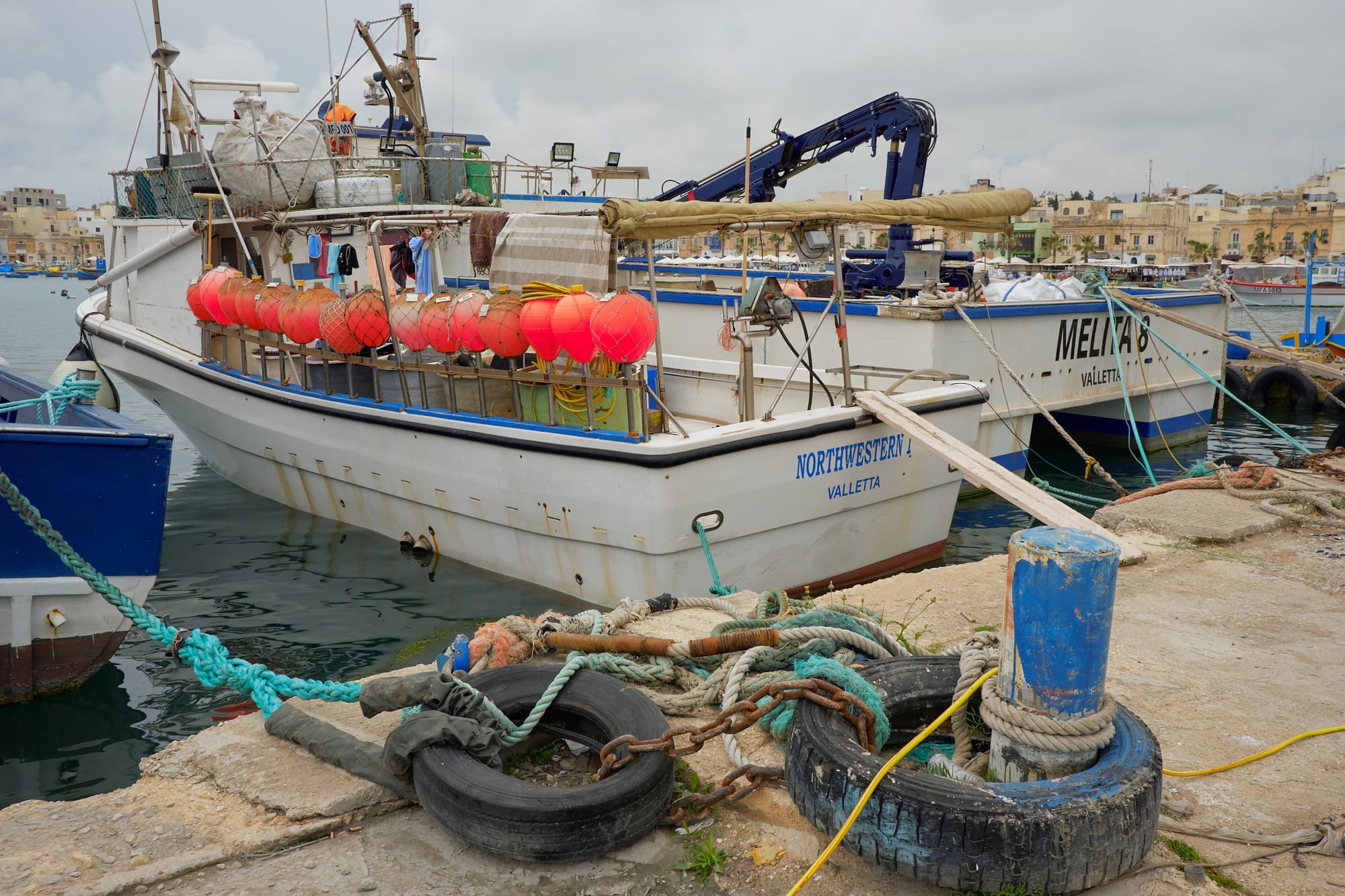 orange floats on the side of a fishing boat