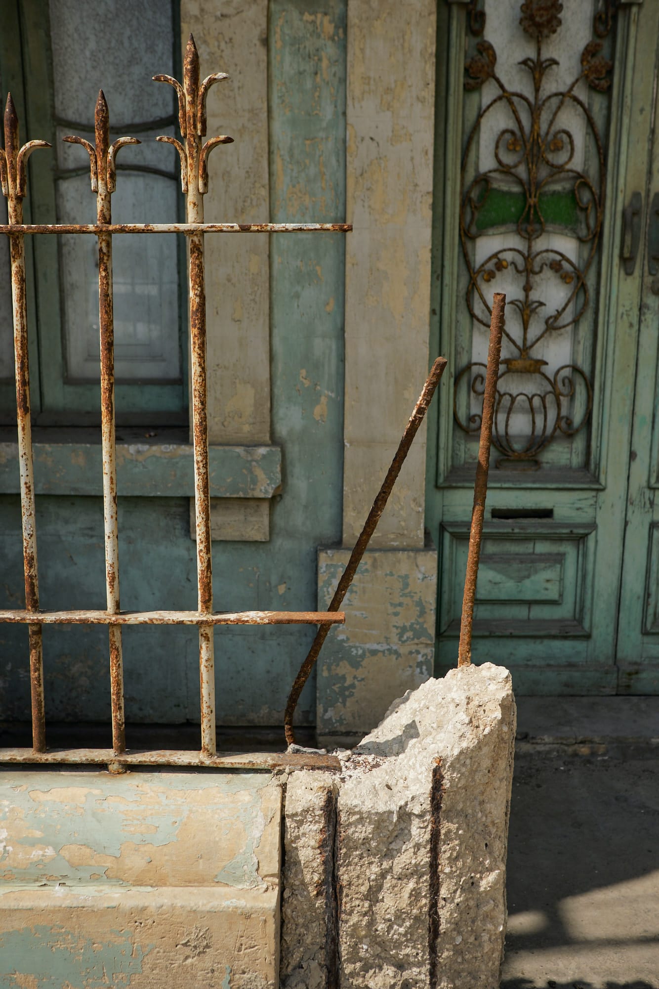 broken concrete gatepost and rusty fence