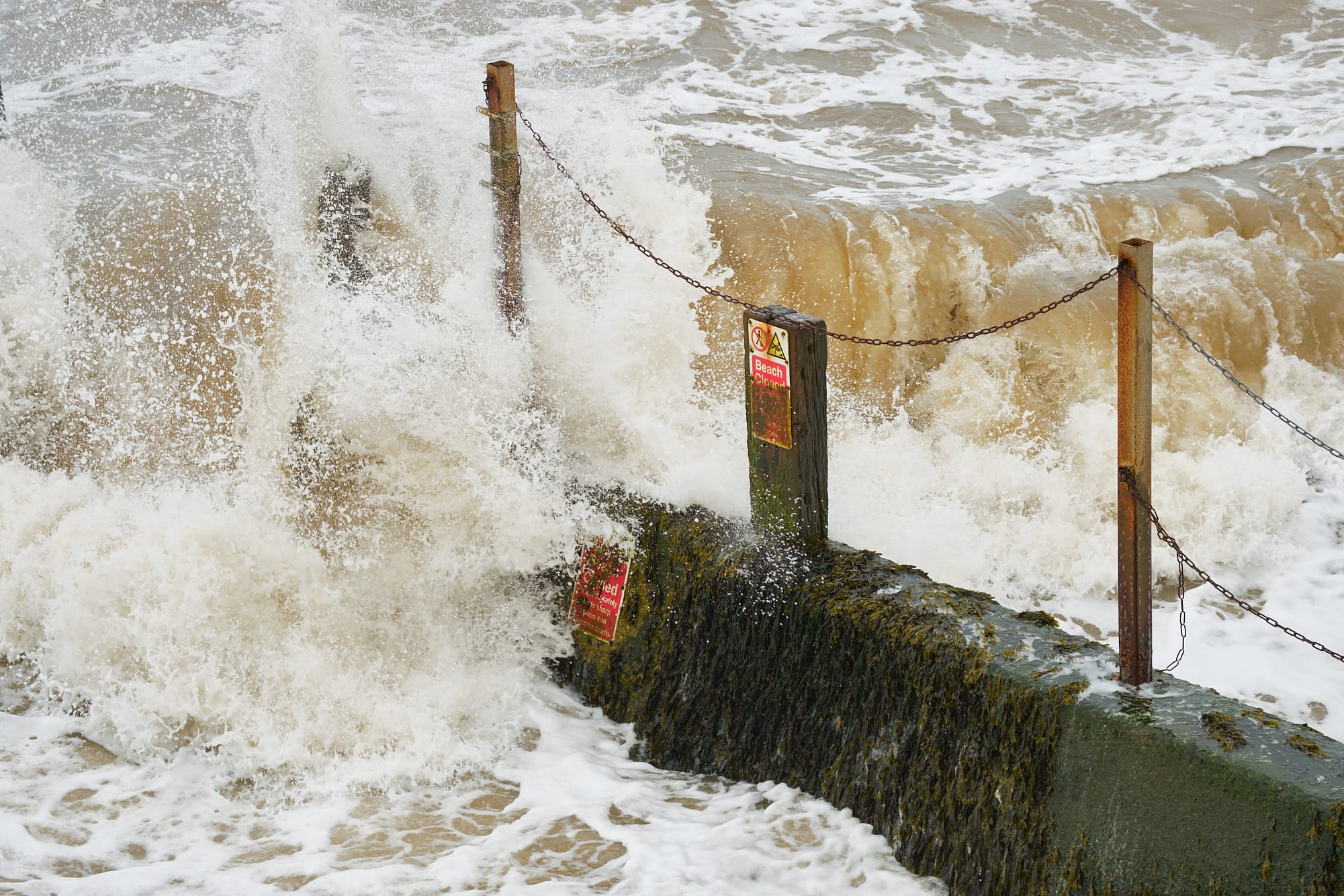 waves crashing over a groyne