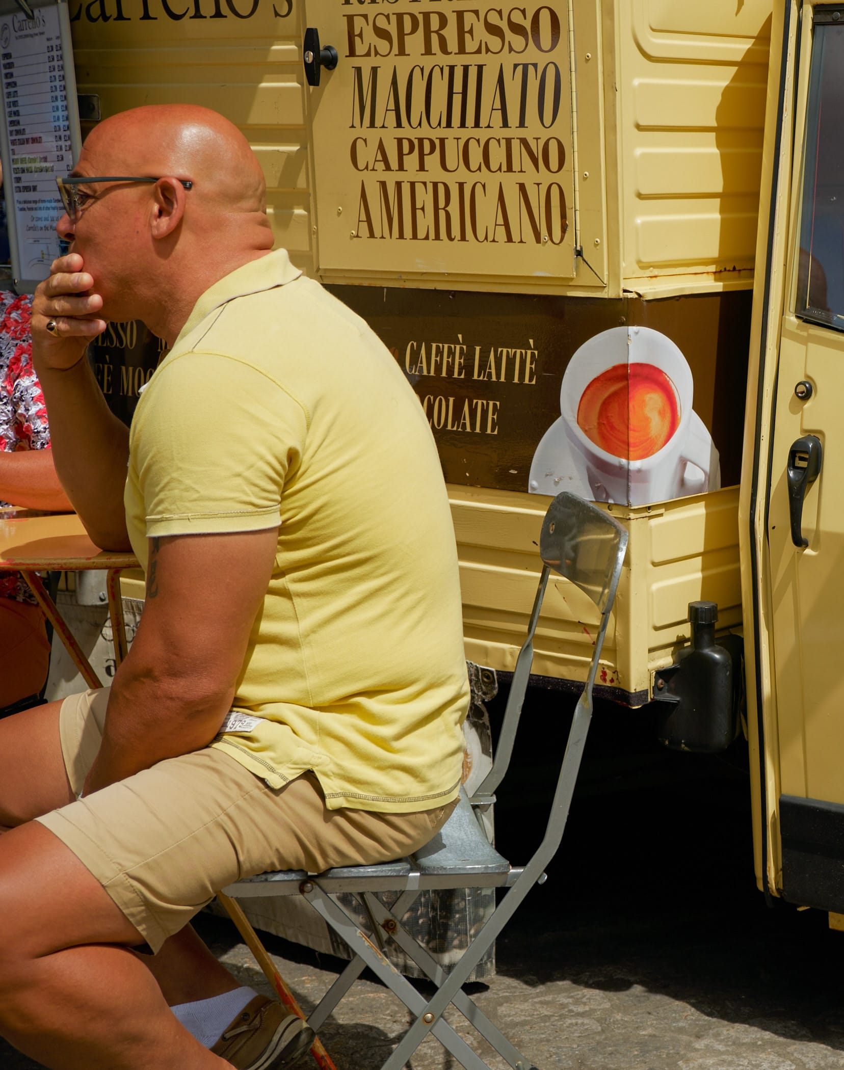 man in yellow shirt in front of coffee van