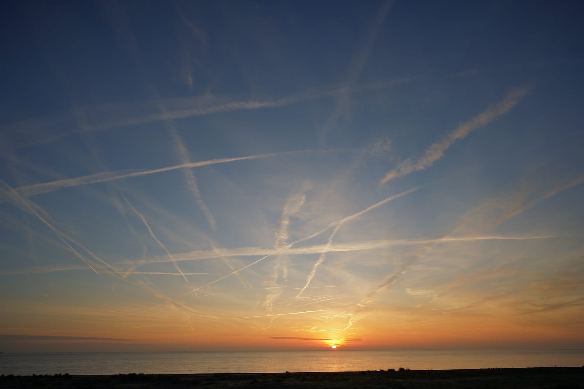 contrails across the dawn sky