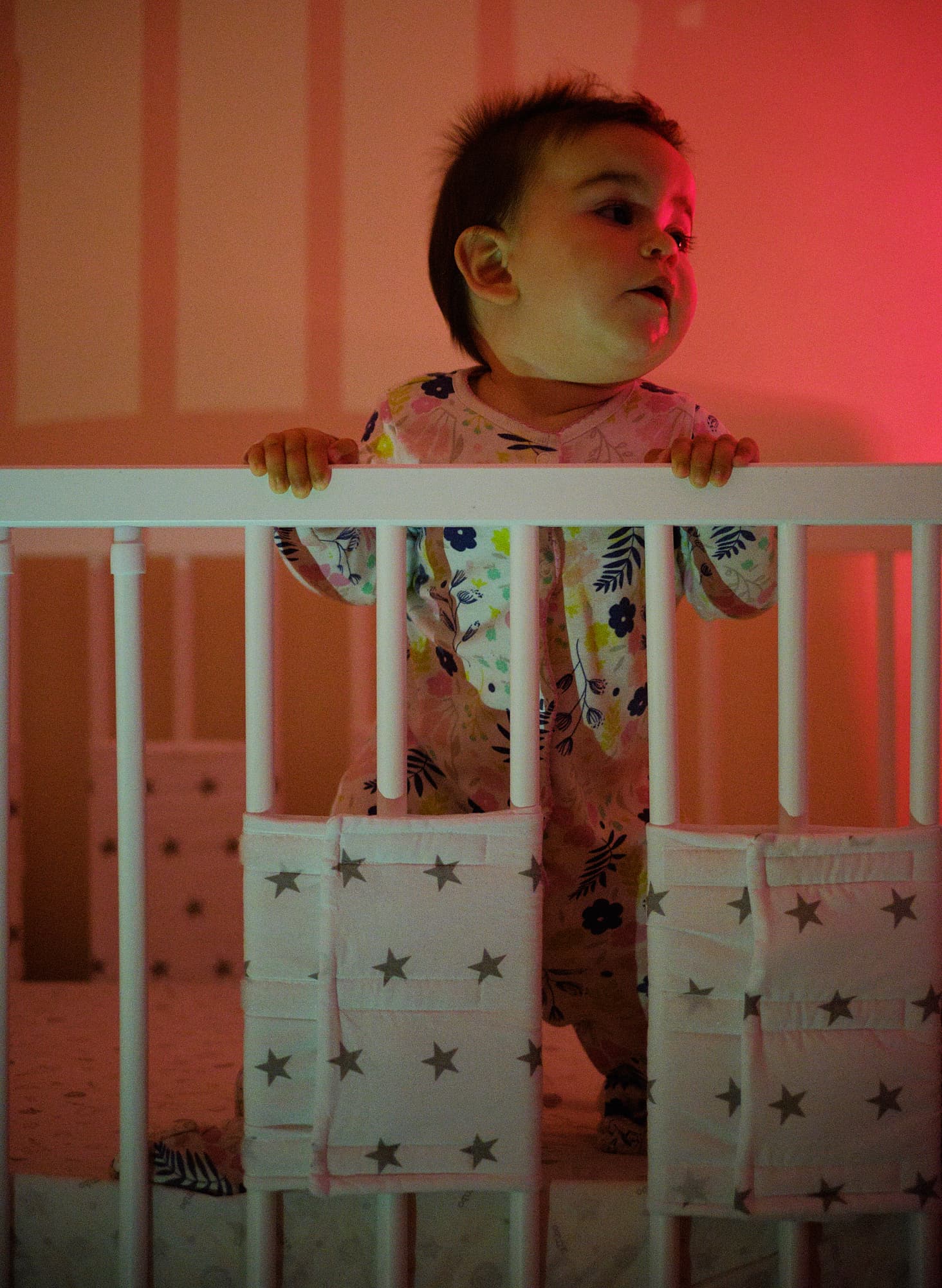 Em standing up in her cot, lit by a lava lamp