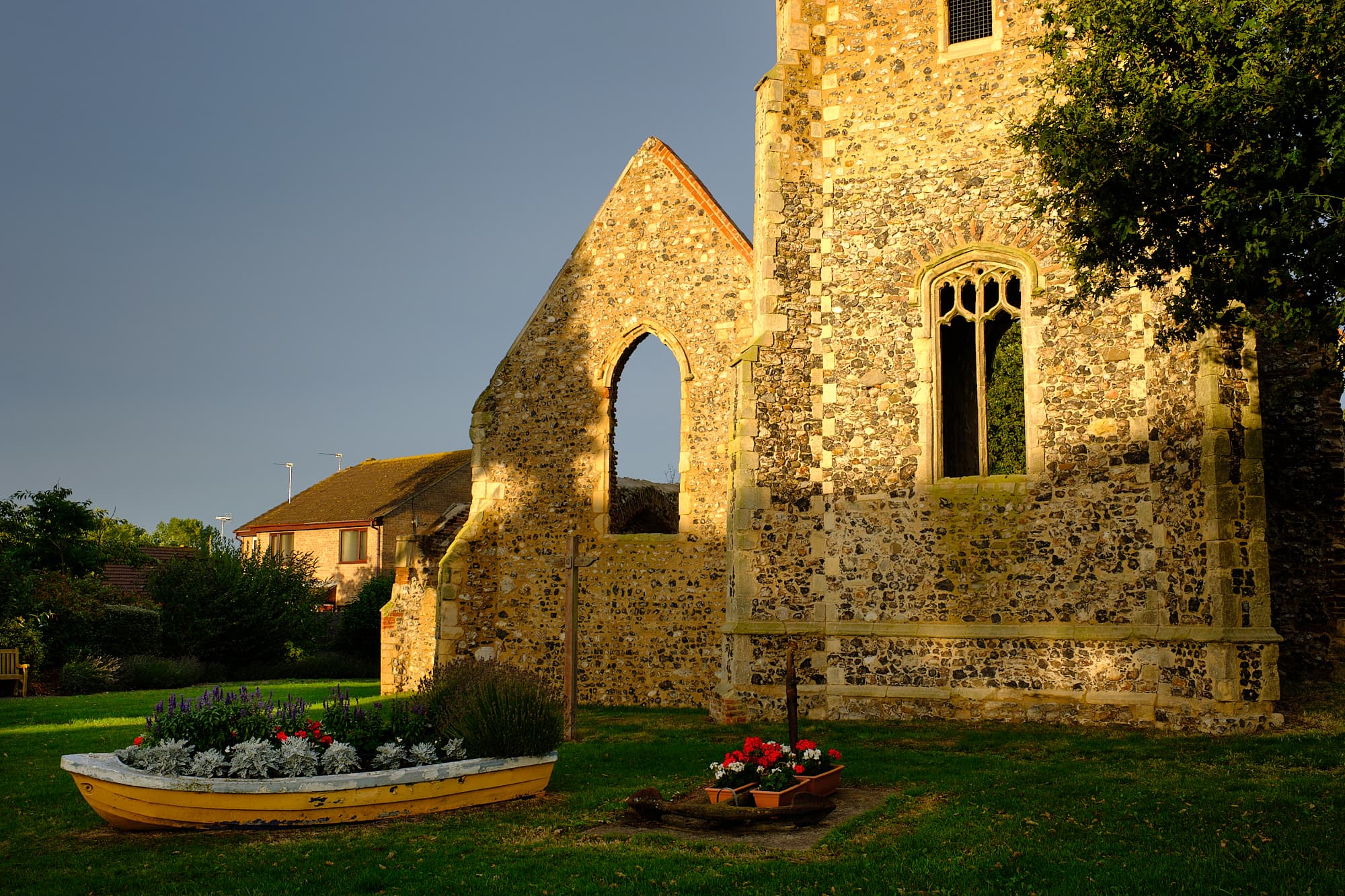 rainclouds behind the sunlit church ruins in Hopton