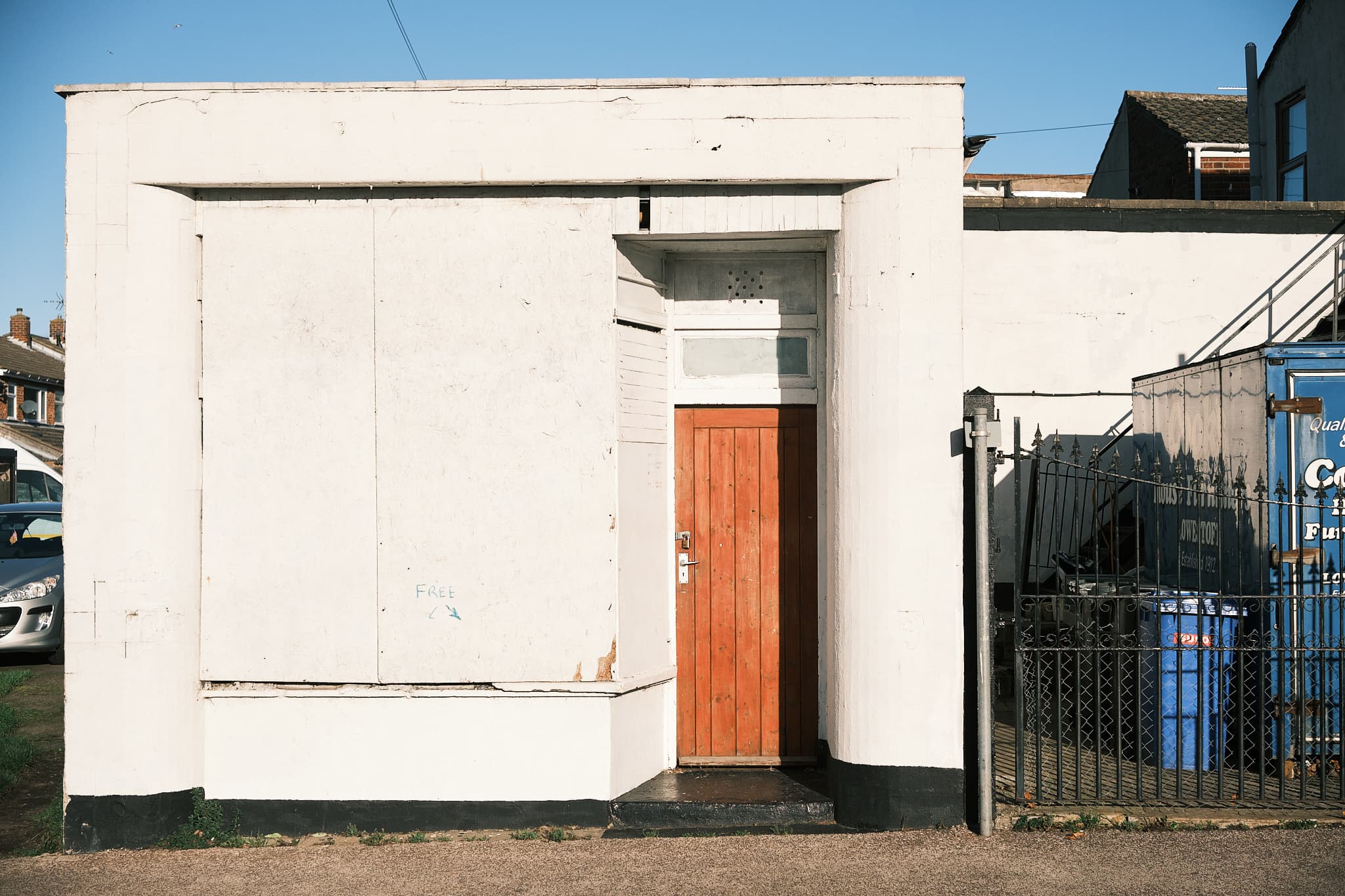 white abandoned building with a brown door