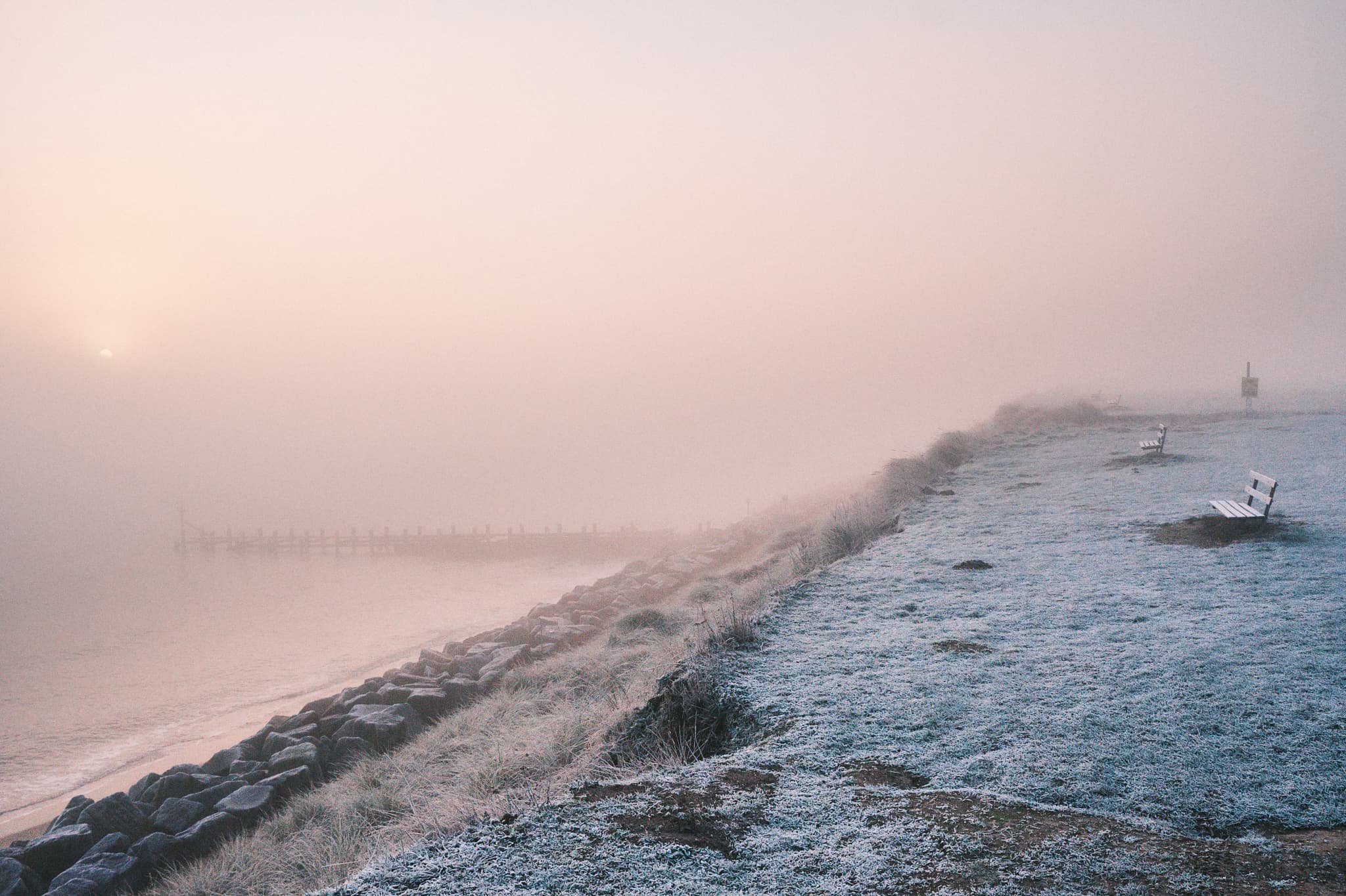 benches facing the early morning fog over Hopton beach