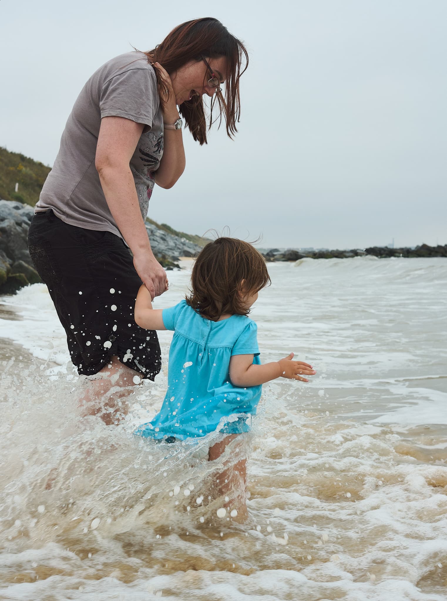 Zoe and Emily braving the waves on Hopton beach