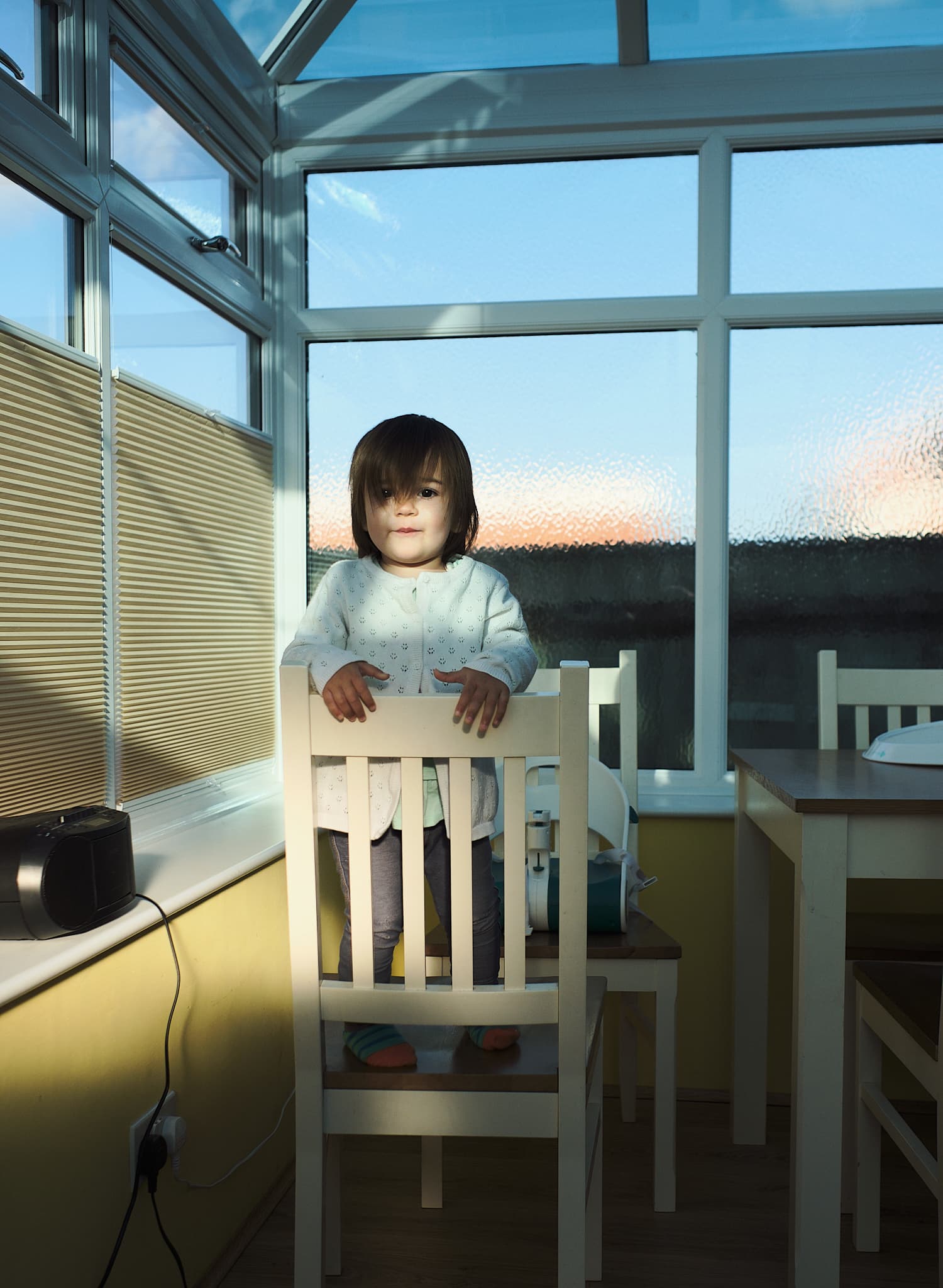 Emily standing on a chair, in a sunbeam