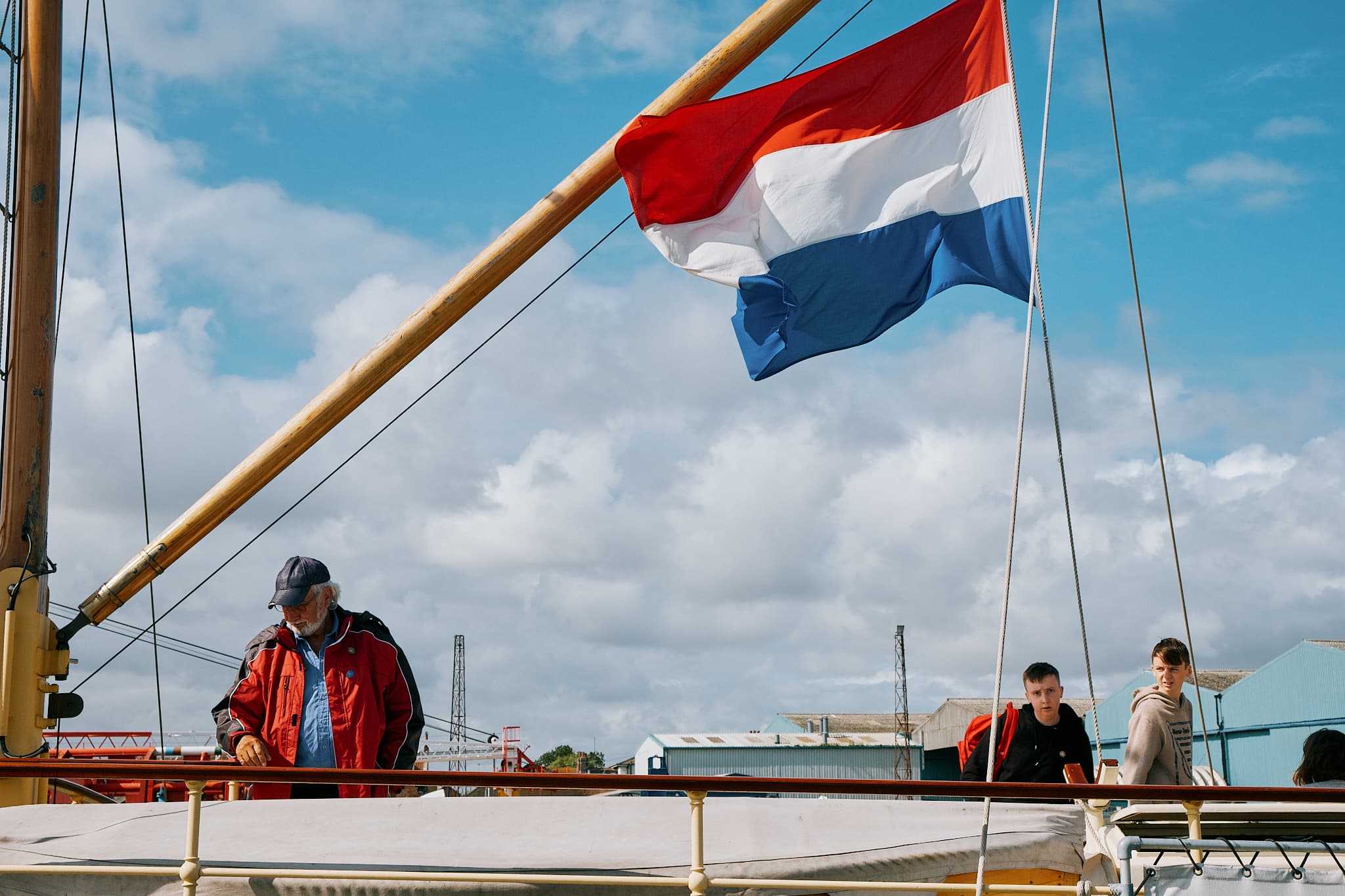 man on a boat beneath a Dutch flag