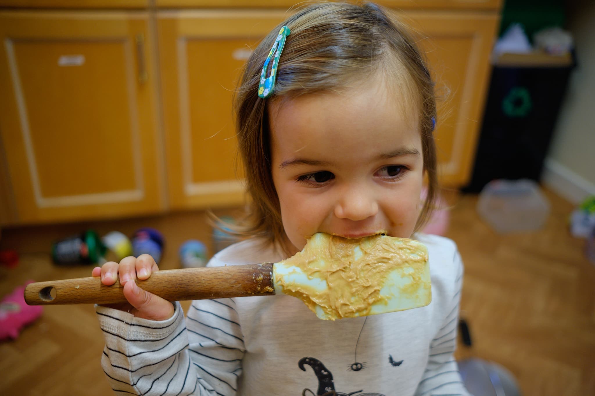 Em licking the spatula while we were making cake