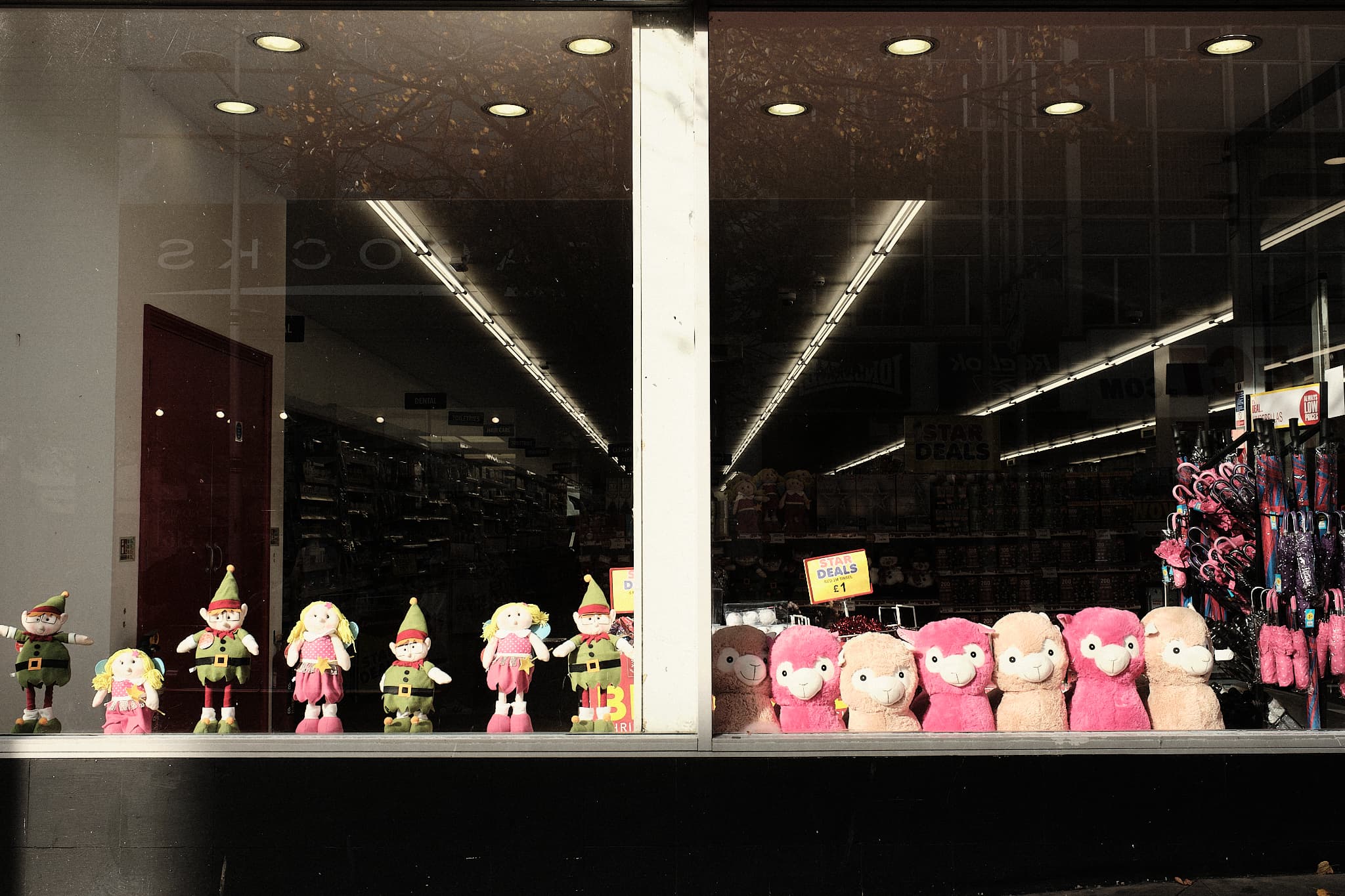 dolls and plush toys lined up in a shop window