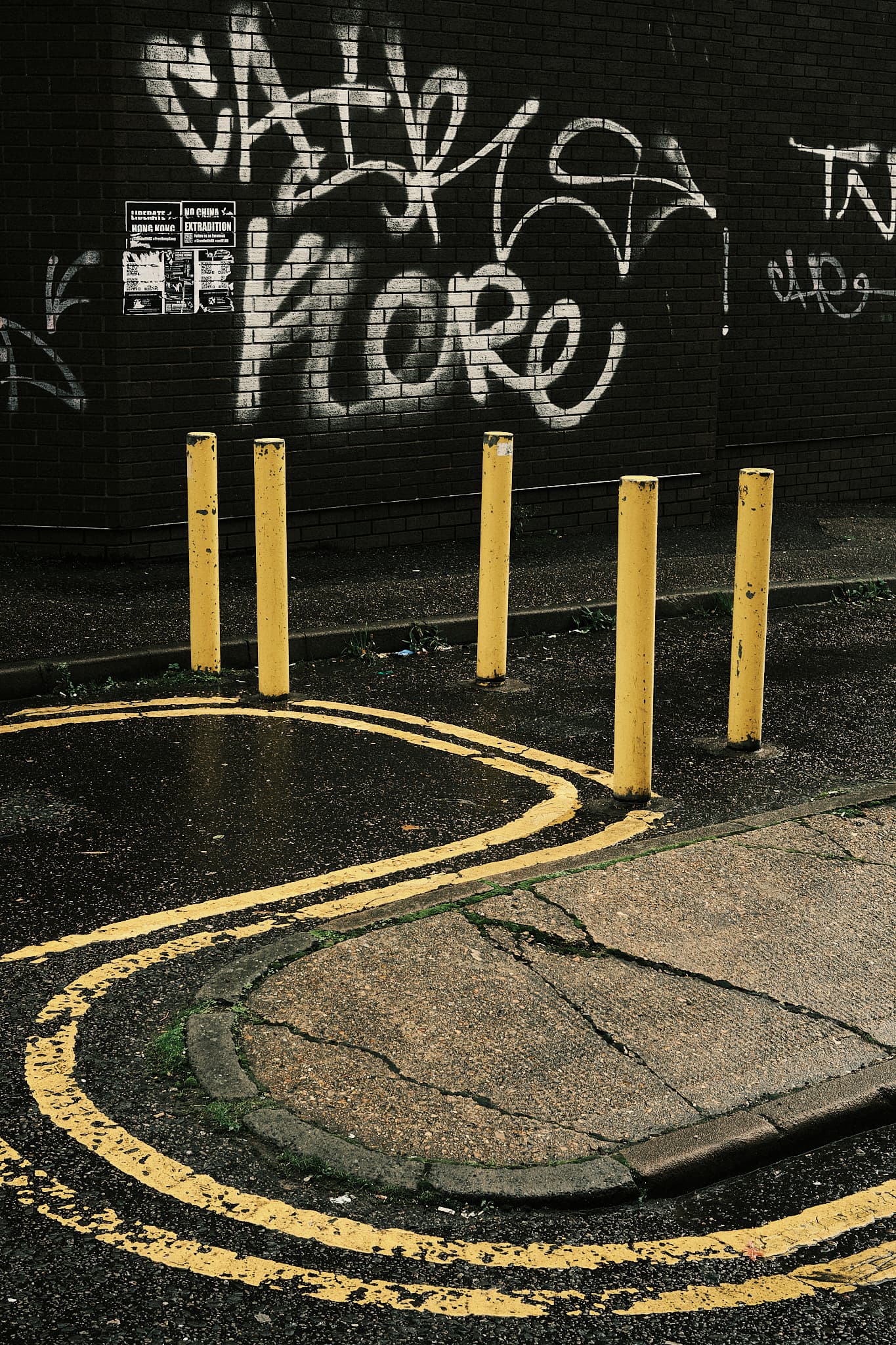 yellow lines, yellow posts, white graffiti