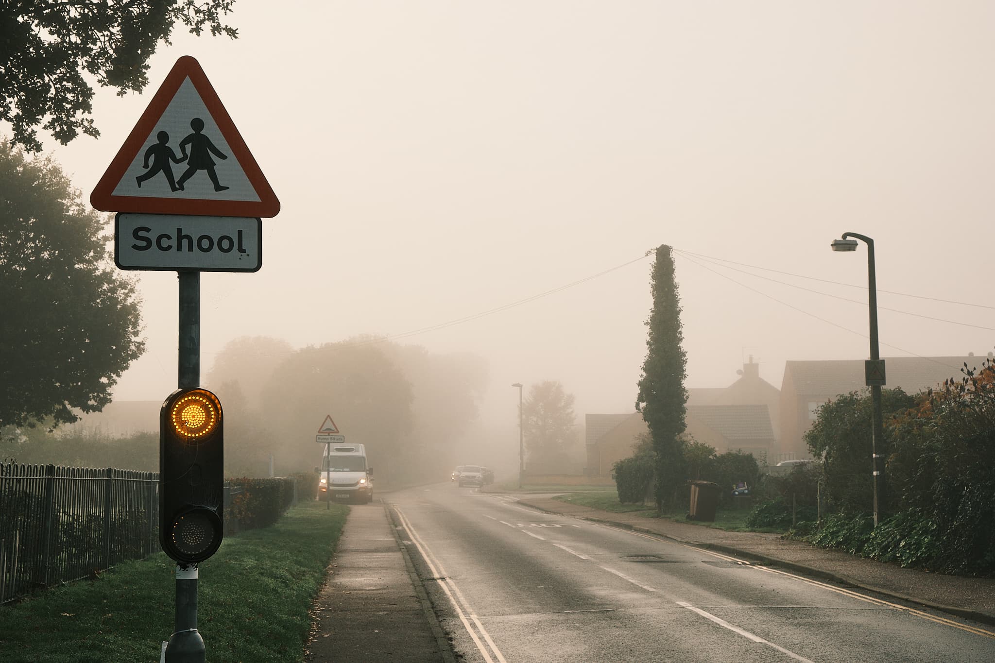 school warning light on a foggy road