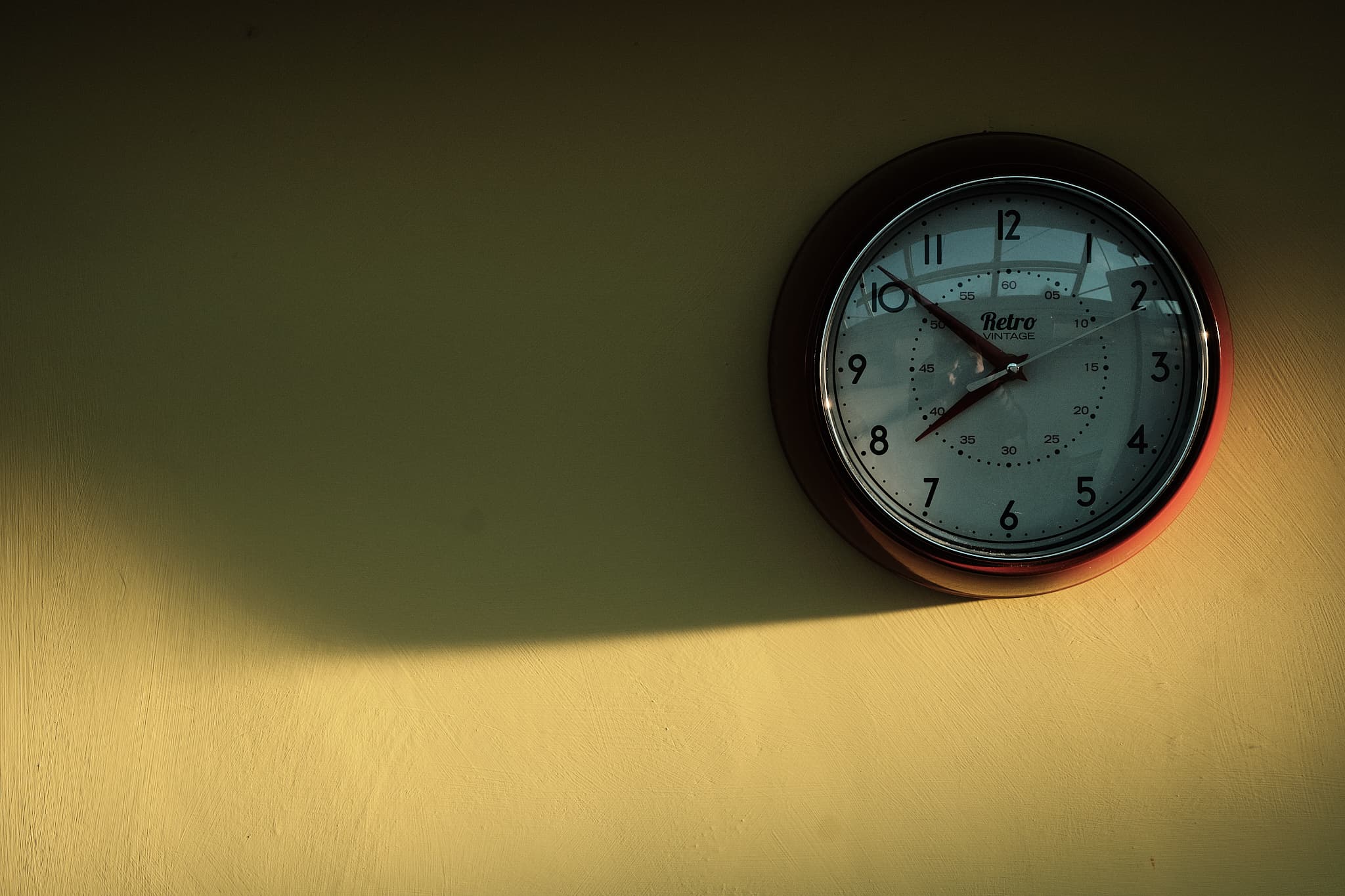 sidelit clock on a yellow wall